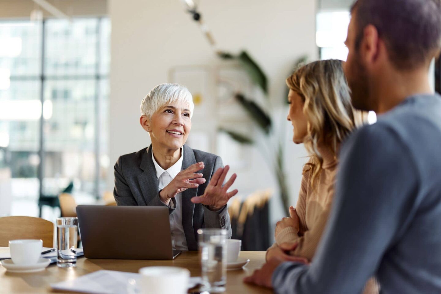 White haired lady talking to young couple