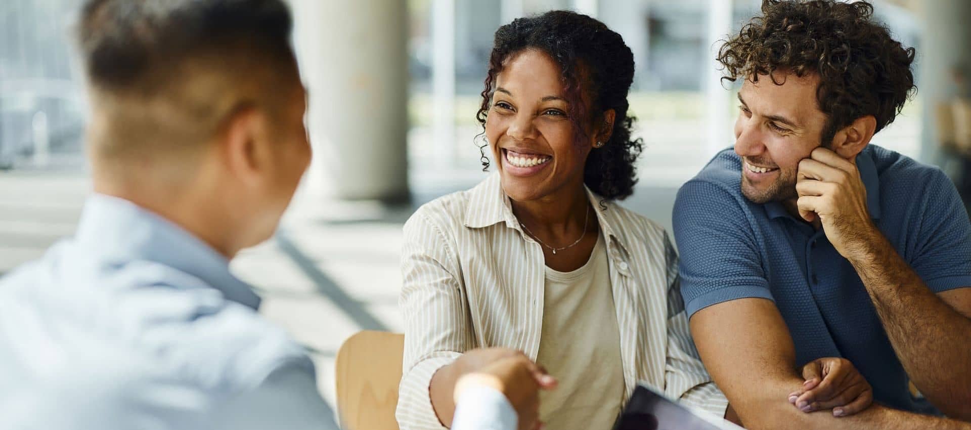 Couple shaking hands with man